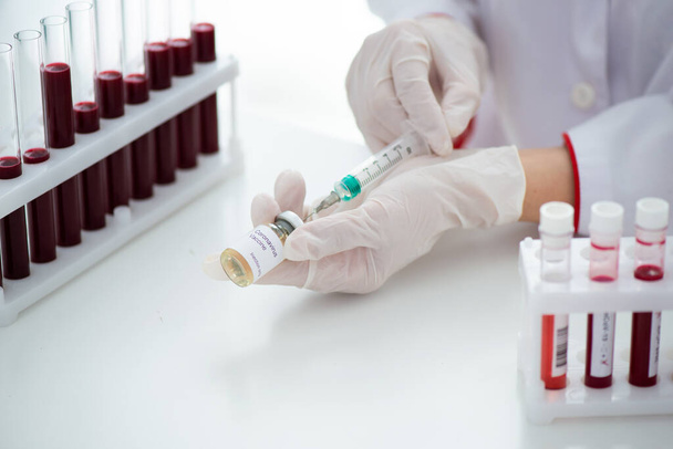 Testovací zkumavky s krevním vzorkem Covid-19 koronavirus. Vakcína a injekční stříkačka Používá se k prevenci, imunizaci a léčbě COVID. - Fotografie, Obrázek