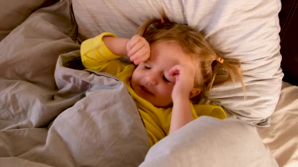 Spokojny mały zrelaksowany dziewczyna w łóżku przed snem - Materiał filmowy, wideo