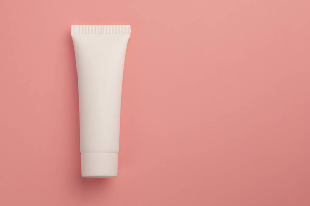 Přírodní organické kosmetické krém v bílé trubici, péče o pleť mokup koncept na prášek růžové pozadí - Fotografie, Obrázek