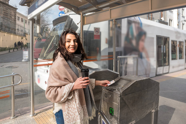 Mooi jong meisje maakt gebruik van metrokaart om het woon-werkverkeer tarief te betalen en voer turnstile in transit systeem in Istanbul, Turkije.Traveler vrouw levensstijl Concept. - Foto, afbeelding