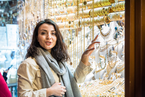 Mujer hermosa en ropa moderna de moda mira en la joyería de oro tienda de puesto en gran Bazar, Estambul, Turquía.Moderno estilo de vida de las mujeres o viajar cóncavo turístico
 - Foto, imagen