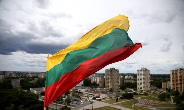 De Litouwse vlag wappert in driekleur over de stad - Foto, afbeelding