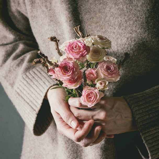 Woman in cashmere sweater hold in hands bouquet of pink roses flowers. St Valentines day love greeting card - Foto, Imagem