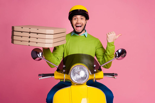 Portrait of his he nice attractive funny cheerful cheery amazed guy riding moped bringing pizza showing cool advert ad new solution isolated over pink pastel color background - 写真・画像