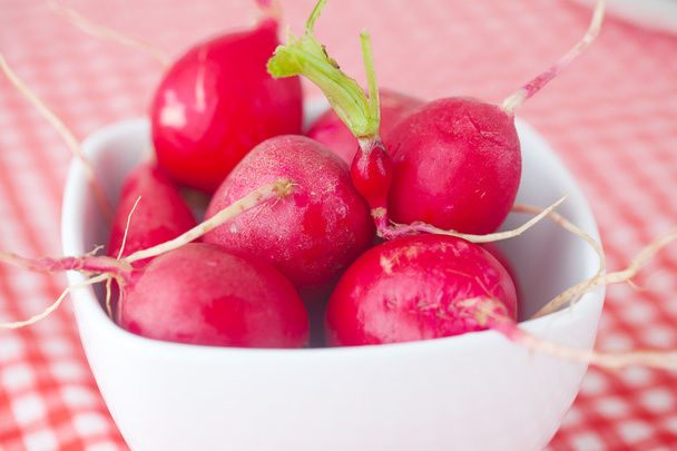 radish in bowl on checkered fabric - Foto, afbeelding