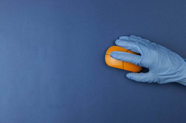 Mavi arkaplanda kopyalanmış mavi eldiven ve bilgisayar faresi  - Fotoğraf, Görsel