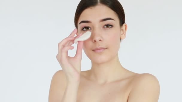 Close up shot of beautiful young woman wiping her bare face with cotton pad, then looking at camera. Skin treatment concept video, touching skin, skin concept video. 4K , Slow motion - Video