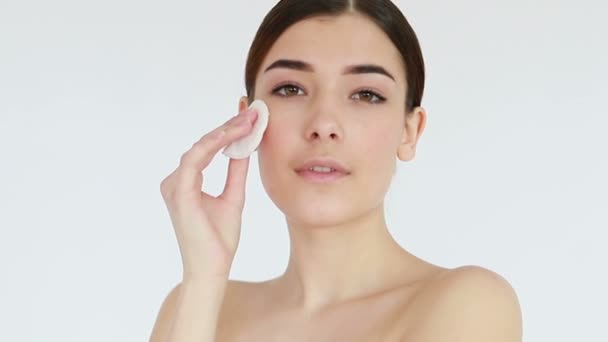 Close up shot of beautiful young woman wiping her bare face with cotton pad, then looking at camera. Skin treatment concept video, touching skin, skin concept video. 4K , Slow motion - Séquence, vidéo