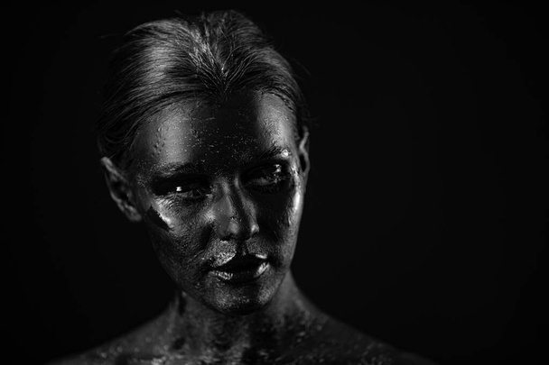art photo of a beautiful woman with black paint face - Фото, зображення