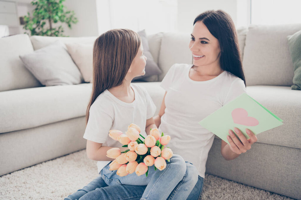 Γοητευτικό αξιολάτρευτο παιδί μαμά απολαύσετε δίνοντας γυναίκα ημέρα άνοιξη δώρα εκδήλωση άνθιση λουλούδια μπουκέτο τριαντάφυλλα καρτ ποστάλ καθίσει ζεστό χαλί στο σπίτι σε εσωτερικούς χώρους - Φωτογραφία, εικόνα