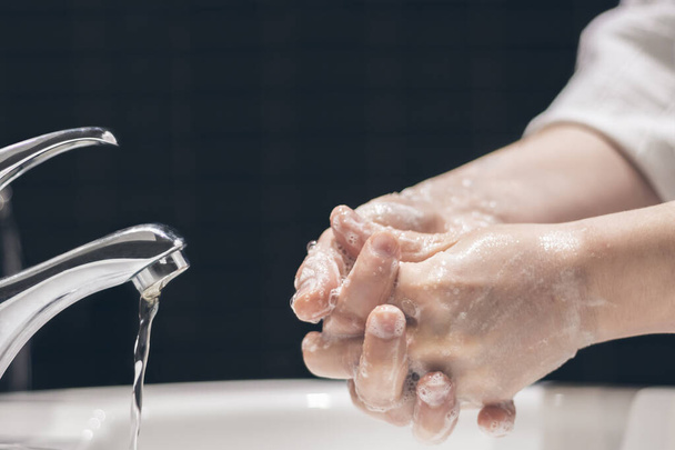 Руки жінки натирають мило і воду в раковині, як щоденну міру гігієни і захист від бруду або вірусів, вибірковий фокус
 - Фото, зображення