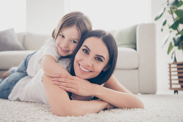Close up photo of cute adorable mom and her daughter have family weekends lay carpet hold small kid piggyback in living room indoors - Fotó, kép