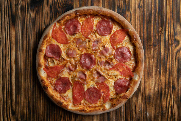 Прямо над порцией итальянской мясной пиццы с беконом, салями, пепперони и курицей, приправленной соусом халапеньо
 - Фото, изображение