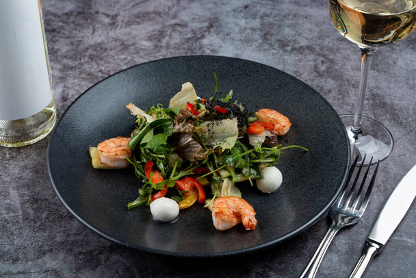 Prawns and mozzarella salad with lettuce on grey stone table  - Foto, imagen