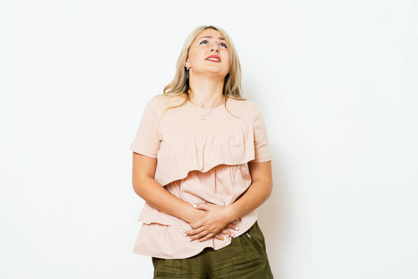 Stomach ache woman against studio background - Valokuva, kuva