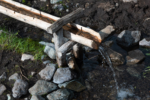 dřevěný akvadukt z potoka, zavlažování a přívod vody dřevěným korytem, uhasící žízeň za horkého dne - Fotografie, Obrázek