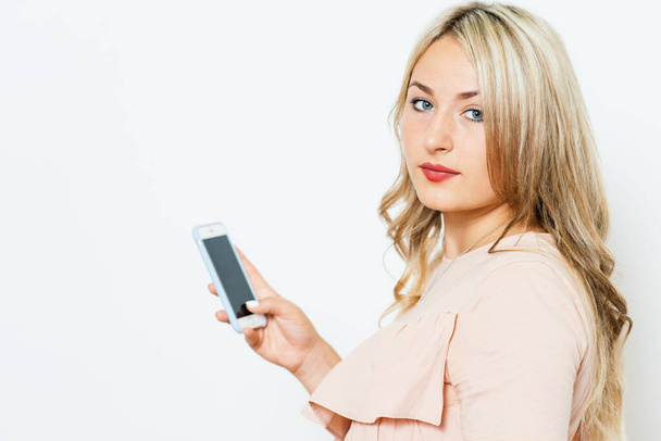 Woman with smartphone against studio background - Zdjęcie, obraz