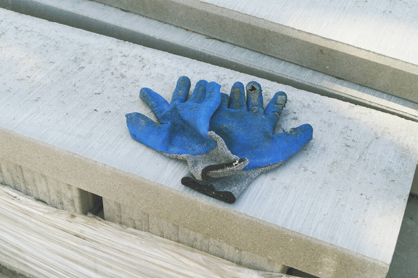luvas de trabalho azul para construção de laje de concreto
 - Foto, Imagem