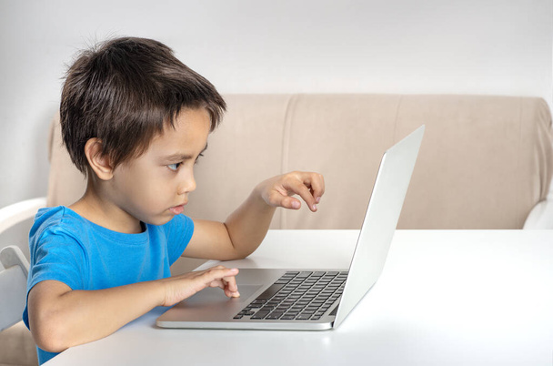 Una foto de un niño jugando en un portátil. Estilo de vida moderno
.   - Foto, imagen