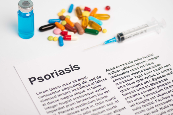Paper with psoriasis lettering near jar, syringe and pills on white background - Фото, зображення
