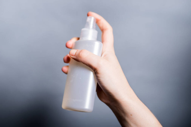 mão segurando uma garrafa de desinfetante
 - Foto, Imagem