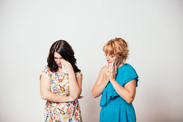 Two women weep against studio background - Zdjęcie, obraz