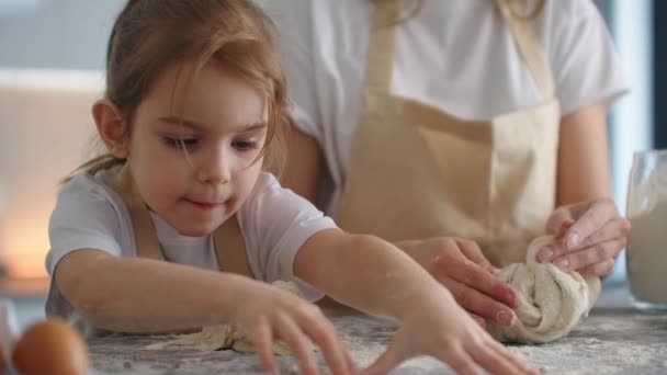 Anya és lánya tésztával főz a konyhában. Anya és lánya szív alakú tészta formát tartanak. Szobrászd a tésztát a kezeddel, hogy üres legyen a pizza vagy pite, süti - Felvétel, videó