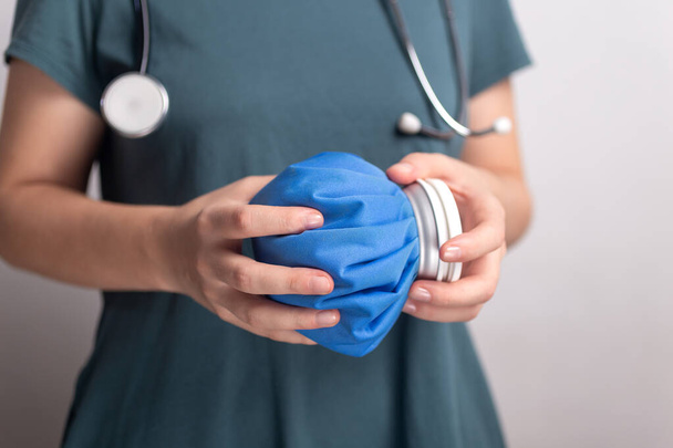 Nainen lääkäri sairaanhoitaja nainen tilalla sininen jääpussi, ensiapu
 - Valokuva, kuva