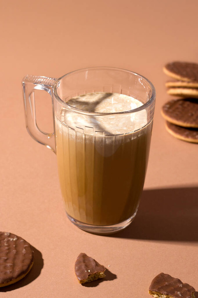 Kávé karamellel és tejszínnel. édes csokis sütik mellett. függőleges fénykép - Fotó, kép