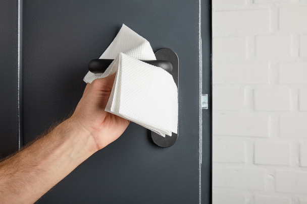 partial view of man cleaning metal door handle with napkin - Photo, Image