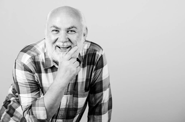 mature bearded man in checkered shirt. positive emotions. happy old grandad. grandfather on retirement. barber and hairdresser salon. male fashion. happy senior man with gray beard. copy space - Fotoğraf, Görsel