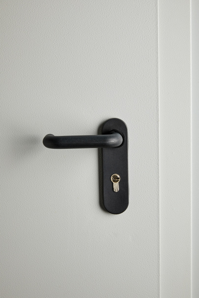 schone grijze metalen deur met zwarte handgreep na desinfectie - Foto, afbeelding