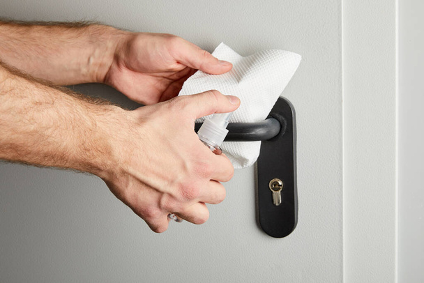 partial view of man disinfecting door handle with antiseptic and napkin - Fotoğraf, Görsel