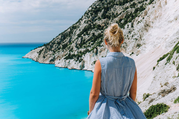 Women tourist enjoying Myrtos Beach. Travel vocation concept. Kefalonia, Ionian Sea, Greece - 写真・画像