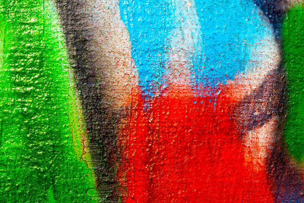 Θραύσμα από πολύχρωμο γκράφιτι ζωγραφισμένο σε τσιμεντένιο τοίχο. Φωτεινό αφηρημένο σκηνικό για σχεδιασμό. - Φωτογραφία, εικόνα
