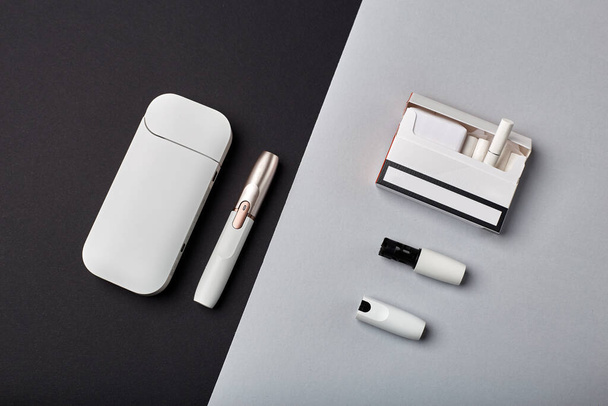 Electronic Cigarette Technology. Tobacco IQOS system. Close-up an electric hybrid cigarette with a heating pad. tobacco heating system. New tobacco heating system. Electronic cigarette mocap. - Foto, Imagem