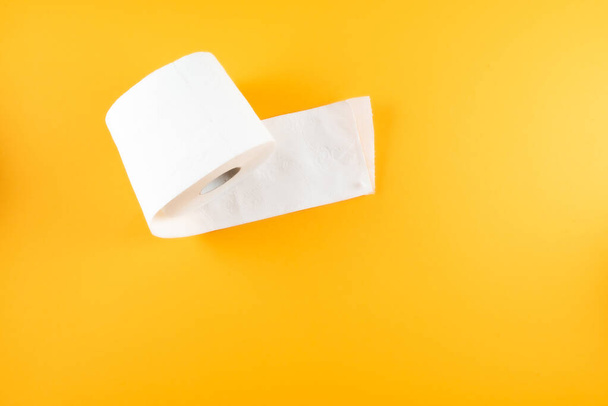 Draufsicht auf Toilettenpapierrolle auf orangefarbenem Hintergrund - Foto, Bild