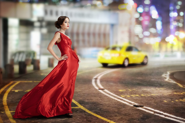 Young beauty famous woman in fluttering red dress, - 写真・画像