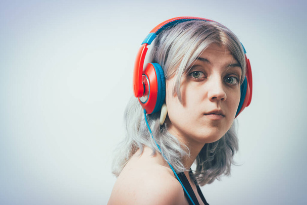 Woman with headphones against studio background - Foto, Imagen
