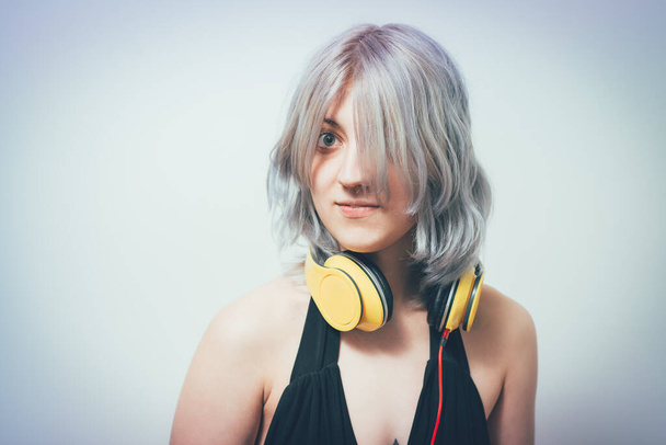 Mujer con auriculares contra fondo de estudio - Foto, Imagen