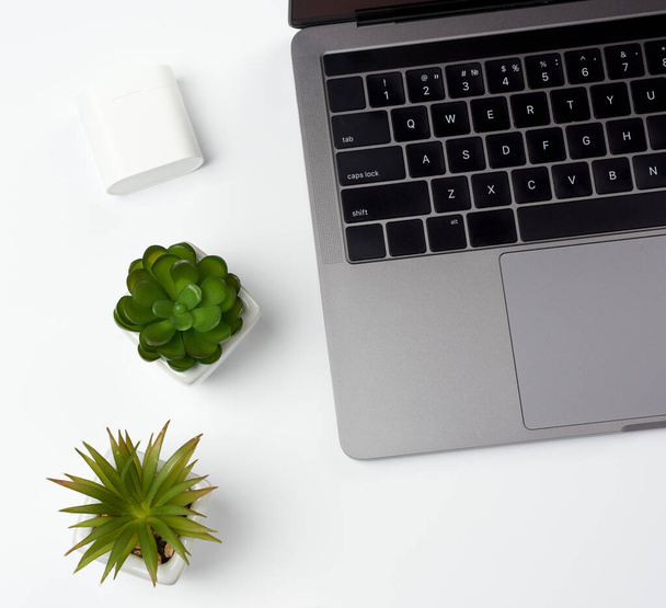 открытый серый ноутбук стоит на белом столе, фрилансер рабочее место, бизнесмен, вид сверху
 - Фото, изображение