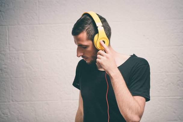 Homem com fones de ouvido contra fundo estúdio - Foto, Imagem