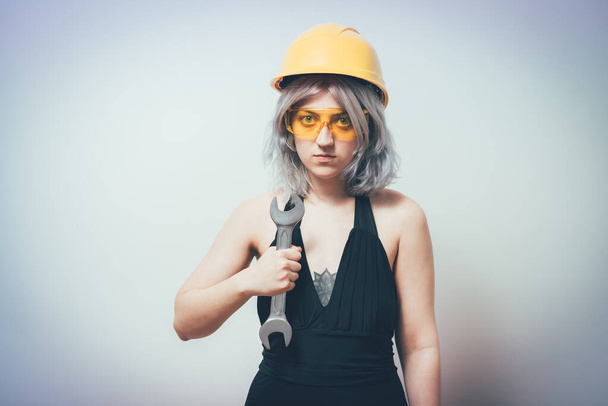 girl in a yellow helmet with a key - Foto, imagen