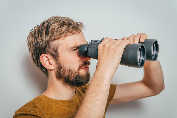 man with binoculars. gray background - Foto, afbeelding