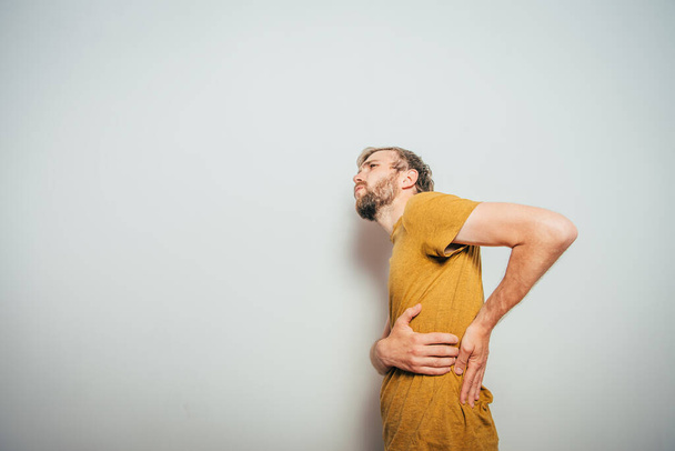 man with backache against studio background - Foto, Bild
