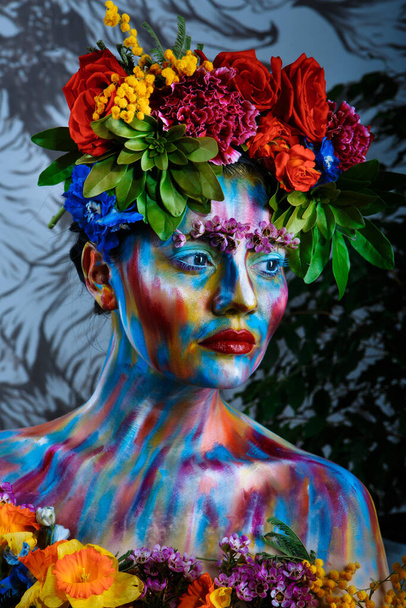 Portrait of a girl whose face is painted with colored paints in a wreath of flowers. In Frida Kahlo's footsteps - Foto, immagini