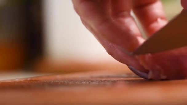 θηλυκά χέρια ενός μάγειρα με ένα μαχαίρι κουζίνας διαχωρίζουν τον τένοντα από το χοιρινό κρέας - Πλάνα, βίντεο