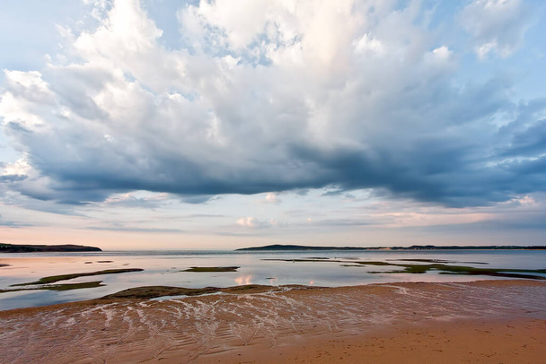 Piękne chmury nad płytkimi wodami i piaszczysta plaża. Minimalistyczny krajobraz Australii - Zdjęcie, obraz