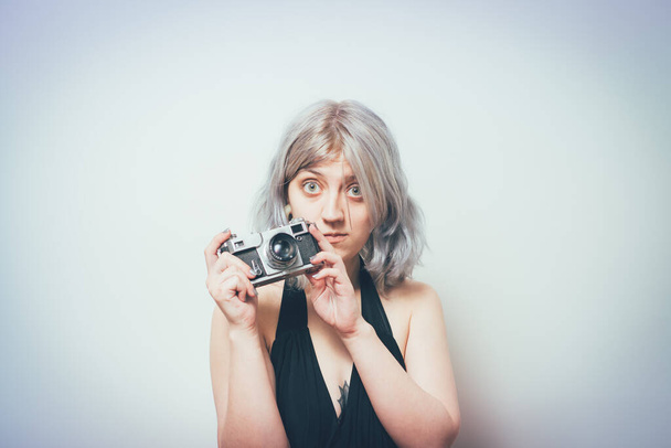 Woman with camera against studio background - Foto, Bild
