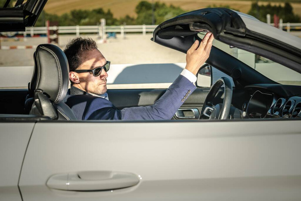 Sommerzeit Cabrio Sporty Car Drive. Kaukasische Männer in seinen 30er Jahren öffnen Fahrzeugdach. - Foto, Bild